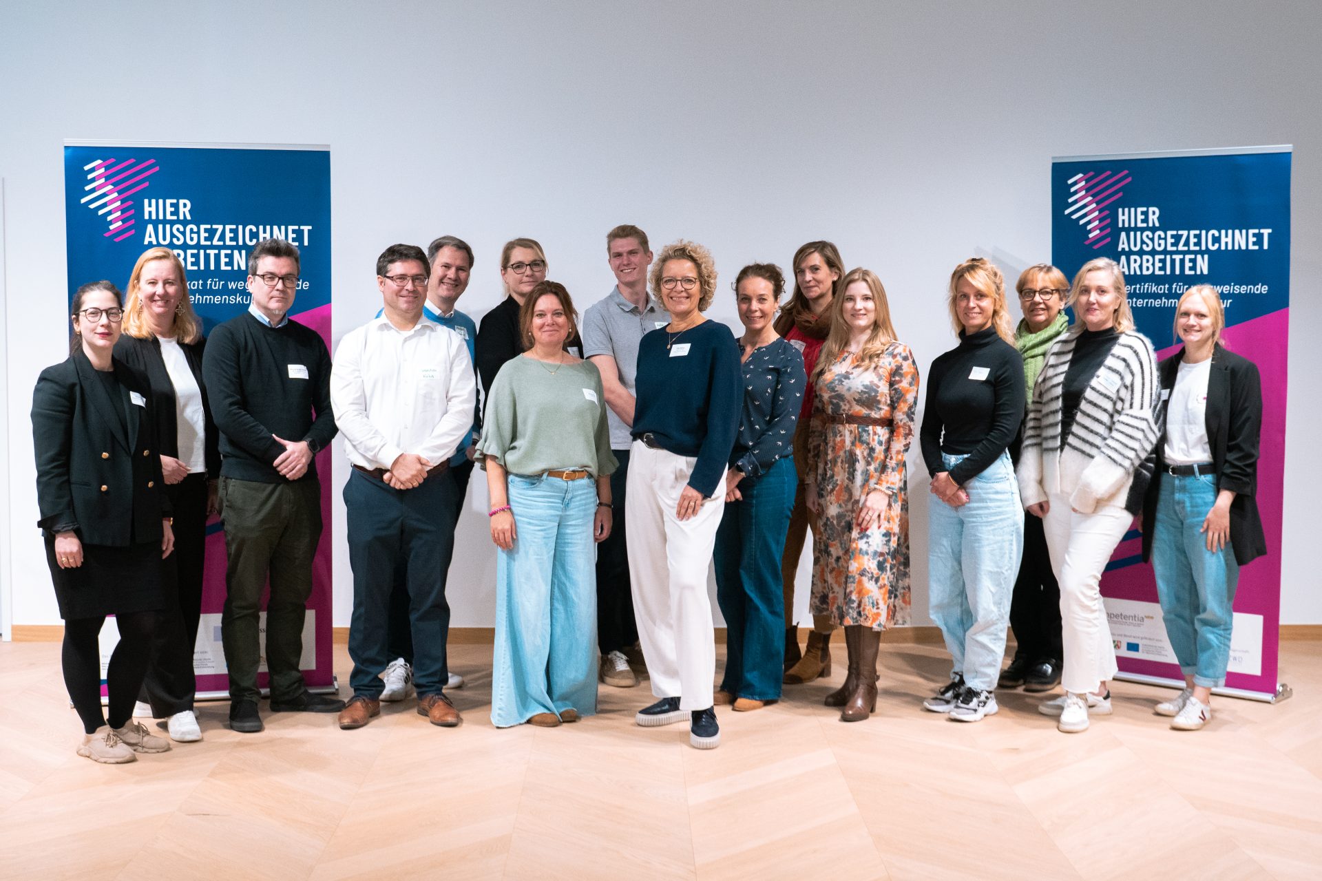 Gruppenfoto von rund 16 Unternehmensvertreterinnen und -vertreterdes Netzwerktreffen ‚Künstliche Intelligenz im Unternehmen‘ teilgenommen haben. Die Personen stehen nebeneinander und blicken lächelnd in die Kamera.